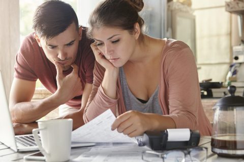 young-female-her-unemployed-husband-with-many-debts-doing-paperwork-together-kitchen