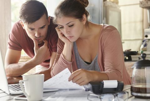 young-female-her-unemployed-husband-with-many-debts-doing-paperwork-together-kitchen